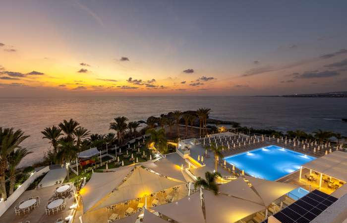 Solnedgang over solterrasse og pool
