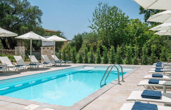 Poolområde med solstole og parasoller 